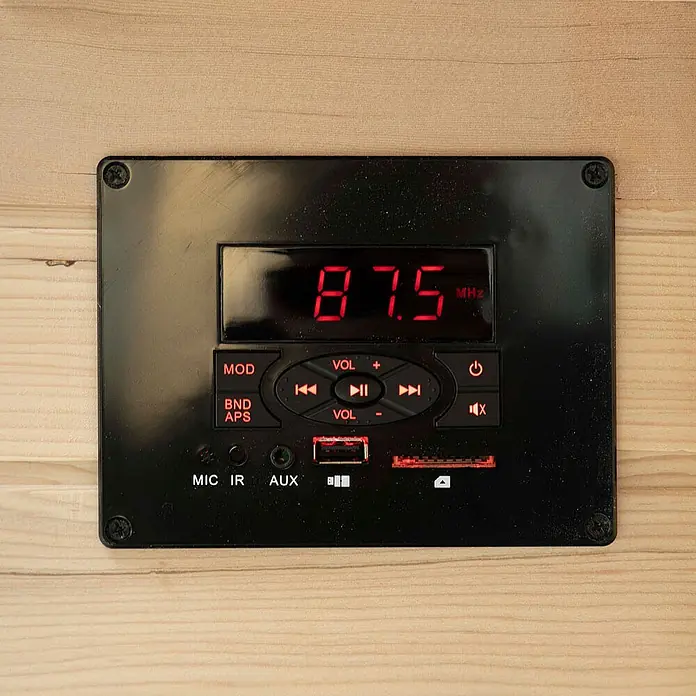 Home Deluxe Infrarotkabine REDSUN S -  - Schwarzes Bedienfeld mit rotem LED-Display zeigt „87.5 MHz“, mit Audiosteuerung, USB, AUX und SD-Kartensteckplätzen.