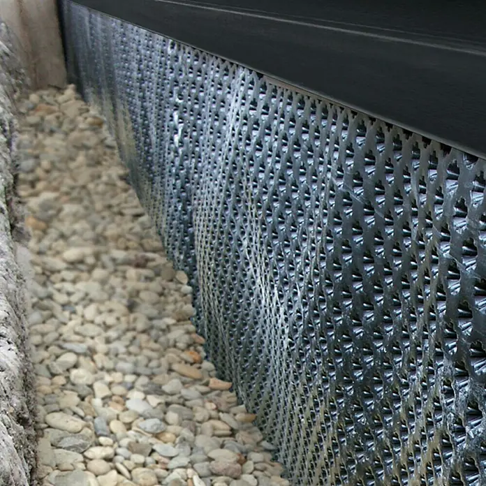 Noppenbahn - 10 x 1 m, Max. Anwendungsfläche: 10 m² - Detailaufnahme einer Drainagebahn mit Noppenstruktur, die zum Schutz vor Feuchtigkeit an einer Wand installiert ist.