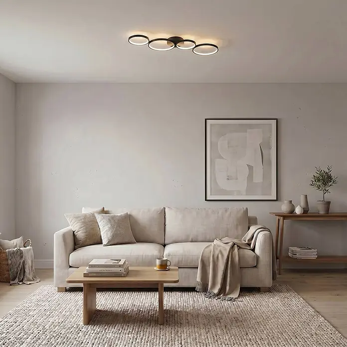 Lindby Deckenleuchte Evengeline - L x B x H: 88 x 31 x 7 cm, schwarz - Modernes schwarzes Ring-LED-Deckenlicht beleuchtet ein Wohnzimmer über Sofa und Couchtisch.