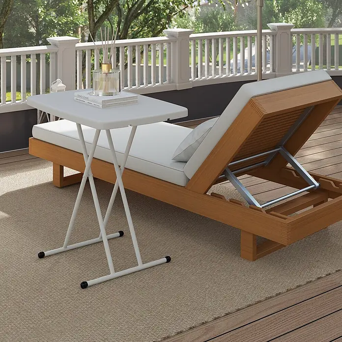Outsunny Campingtisch - L x B x H: 76 x 50 x 74 cm, Kunststoff, Metall, Weiß, Klappbar - Weißer klappbarer Beistelltisch mit X-Gestell, dient als praktische Ablage neben einer Holzliege auf einer Terrasse.