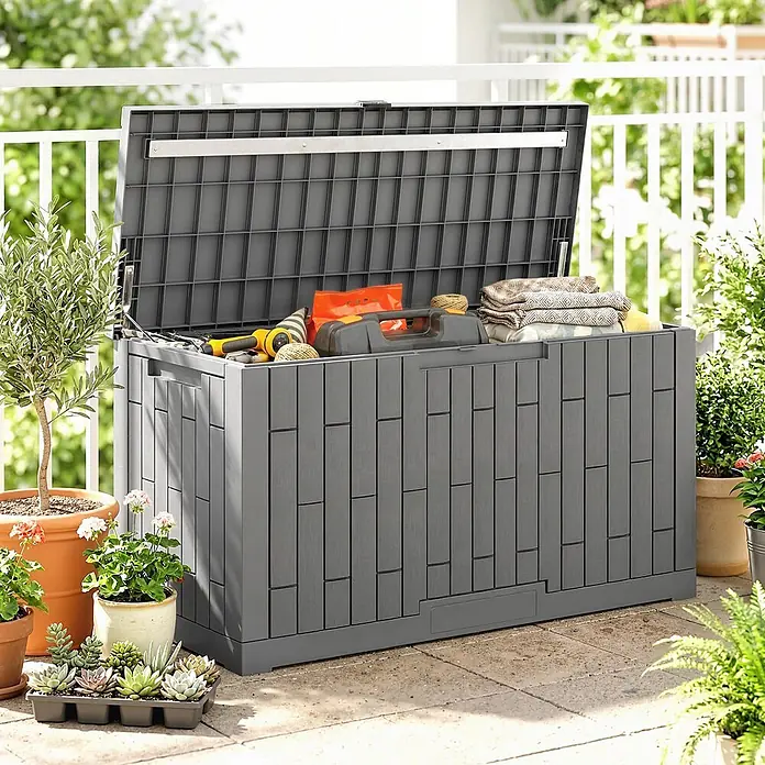 Outsunny Garten-Aufbewahrungsbox - L x B x H: 122,5 x 56 x 62 cm - Große graue Kunststoff-Gartenbox mit geöffnetem Deckel, gefüllt mit Gartengeräten und Textilien, auf einer Terrasse.