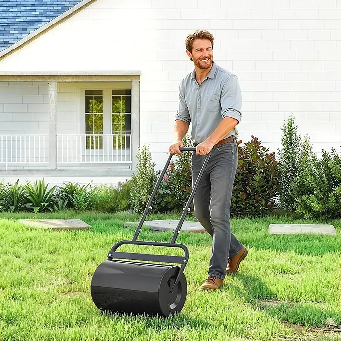 Outsunny Rasenwalze - Passend für: frisch gesäten Rasen und unebene Stellen, Arbeitsbreite: 50 cm, Schwarz - Mann rollt eine schwarze Gartenwalze auf einem Rasen.
