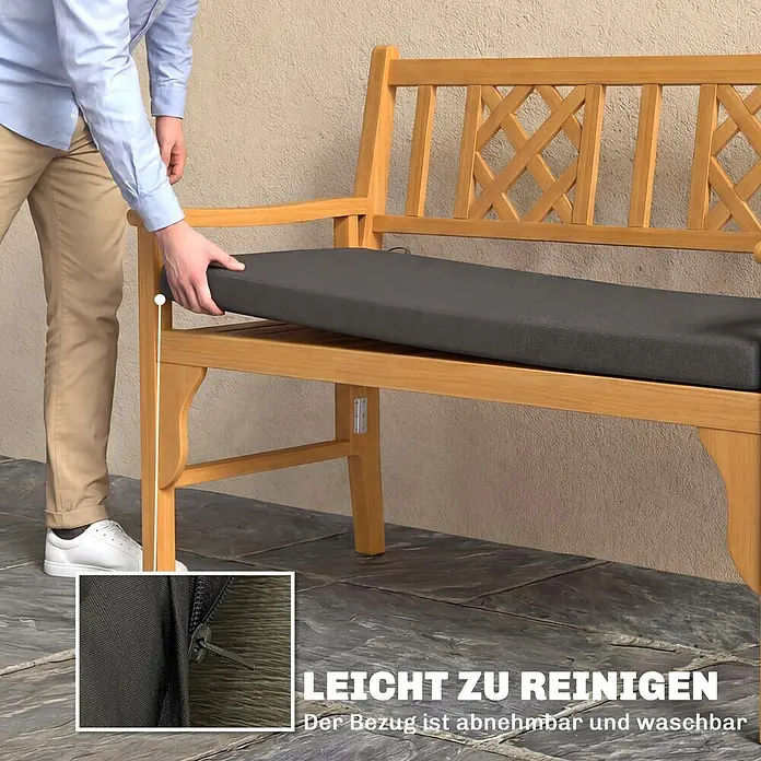 Outsunny Bankauflage - Gartenbank, 1 Stk., L x B x H: 110 x 46 x 6,5 cm, Polyester, Schwamm, Dunkelgrau - Eine Person platziert ein anthrazitfarbenes Kissen mit abnehmbarem, waschbarem Bezug auf einer hellen Holz-Gartenbank. Ein Reißverschluss ist sichtbar.