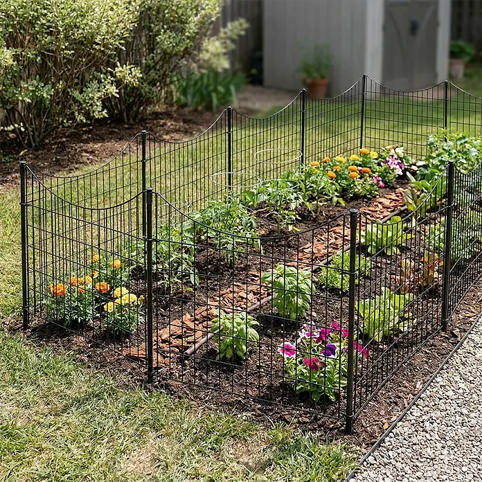 Prestige Home Living Outdoor Teichschutzzaun Set Unterbogen - B x H: 390 x 52,5 cm, Stahl, Anthrazit - Schwarzer Drahtzaun mit Wellenmuster, umgibt ein farbenfrohes Gartenbeet mit Pflanzen und Blumen.
