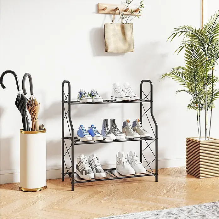 Outsunny Gewächshaus-Regal - 69 x 28,5 x 78 cm, Schwarz - Schwarzes Metall-Schuhregal mit 3 Etagen und Turnschuhen, in einem Flur neben einem Schirmständer.