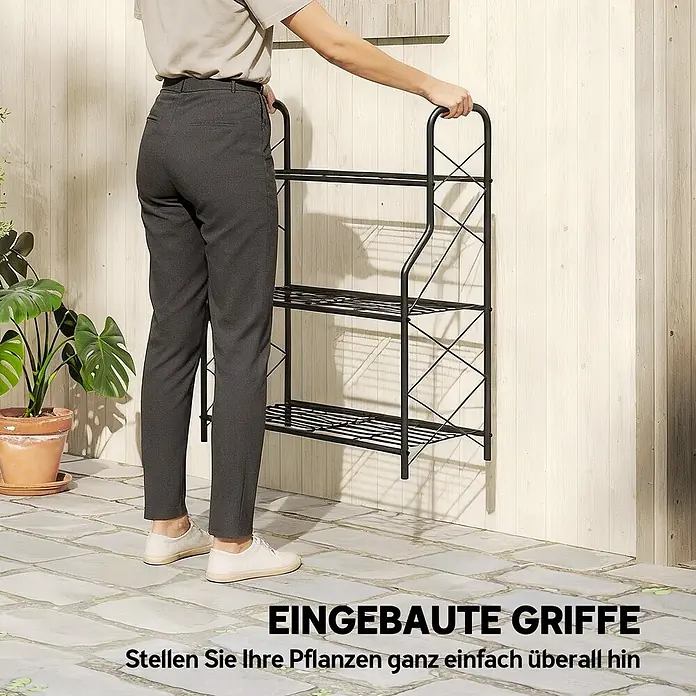 Outsunny Gewächshaus-Regal - 69 x 28,5 x 78 cm, Schwarz - Person bewegt ein schwarzes Metall-Pflanzenregal mit drei Etagen und integrierten Griffen auf einer Terrasse.
