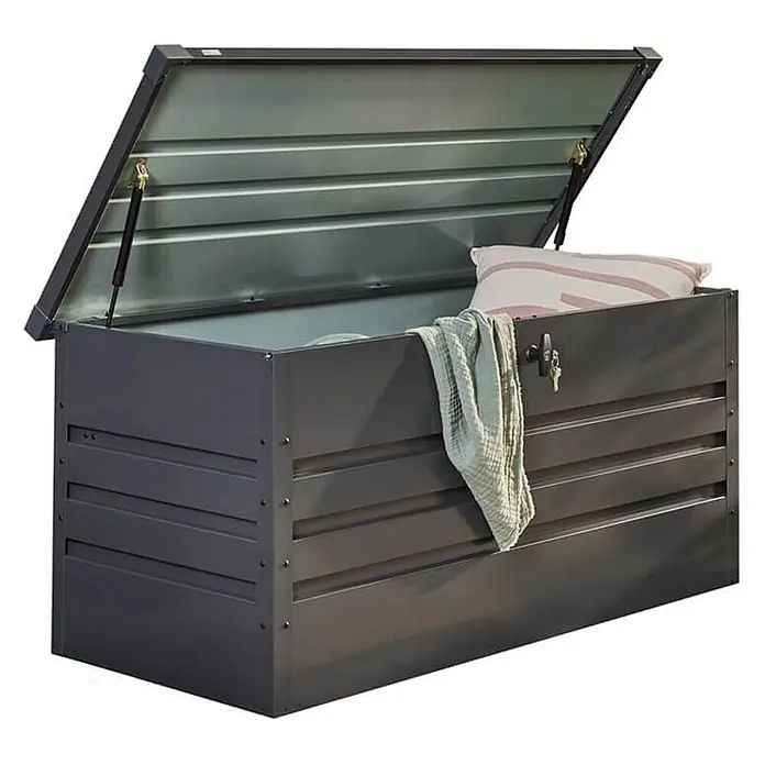 Home Deluxe Garten-Aufbewahrungsbox MEGABOX XXL Größe: 600L - L x B x H: 158 x 64 x 62 cm, Anthrazitgrau, Stahl - Anthrazitfarbene Metall-Gartenbox, Deckel offen, mit Kissen und Decke darin.