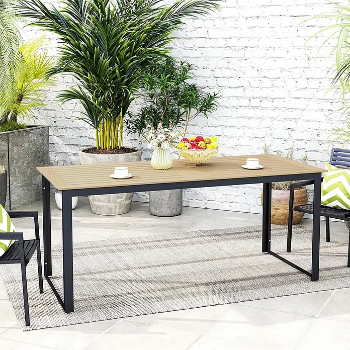 Outsunny Gartentisch mit Platz für 6 Personen - L x B x H: 175 x 78 x 75 cm, Kunststoff, Metall, Rechteck, Teak - Esstisch für den Außenbereich mit hellbrauner Holzlattenplatte und schwarzem Metallrahmen, umgeben von Pflanzen auf einer Terrasse.