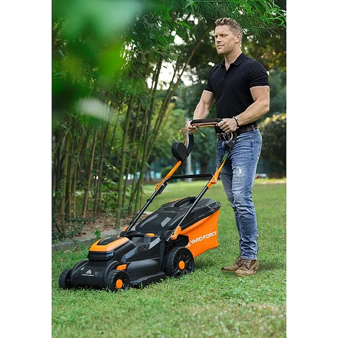 Yard Force Akku-Rasenmäher LM C40B - 40 V, 1 Akku, 4 Ah, Schnittbreite: 400 mm - Ein Mann bedient einen schwarz-orangen Yard Force Rasenmäher auf grünem Gras.