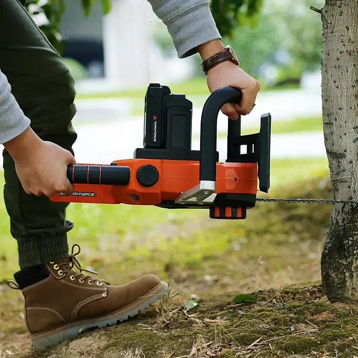 Yard Force Einhand-Akku-Kettensäge LS C35 - 20 V, 2 Ah, 2 Akkus, Schwertlänge: 35 cm - Person schneidet Baum mit orange-schwarzer Akku-Kettensäge.