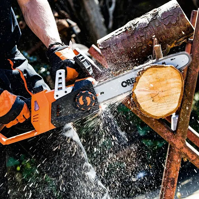 Yard Force Einhand-Akku-Kettensäge LS C35 - 20 V, 2 Ah, 2 Akkus, Schwertlänge: 35 cm - Eine orange-schwarze Kettensäge schneidet einen Baumstamm, Späne fliegen.