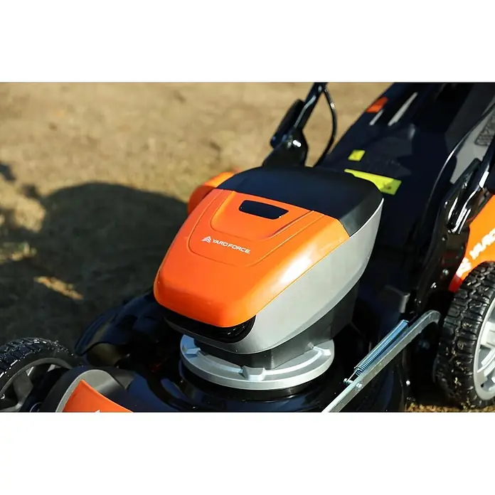 Yard Force Akku-Rasenmäher LM C46 - 40 V, 1 Akku, 5 Ah, Schnittbreite: 46 cm - Nahaufnahme eines orange-grauen YARD FORCE Rasenmähers auf trockenem Gras.
