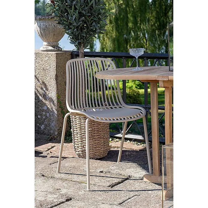 Ebuy24 Gartenstuhl Branson 4er-Set - 4 Stk., PP, Stahl, Sandfarbe, B x T x H: 47 x 55 x 82 cm - Hellbeiger Outdoor-Stuhl mit Lamellen neben einem Holztisch auf einer Terrasse.