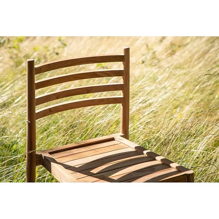 Ebuy24 Gartenstuhl Kenya - 1 Stk., Teak, Teak Dekor, B x T x H: 50 x 52 x 80 cm - Hellbrauner Holzstuhl mit Lattenrücken und -sitz, draußen im hohen Gras.