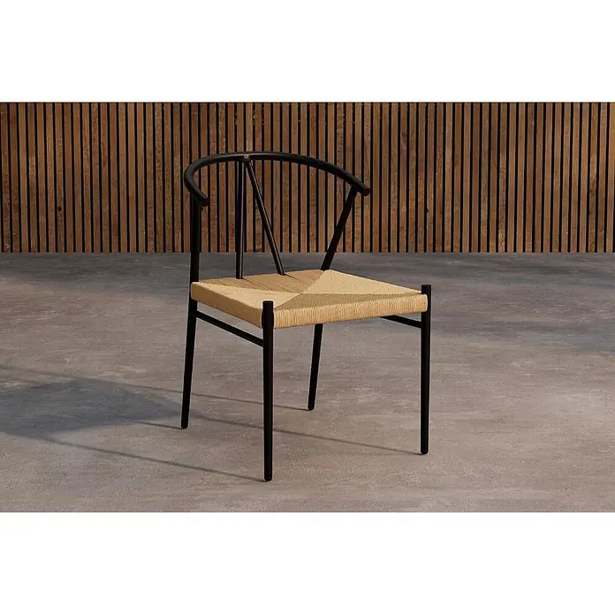 Ebuy24 Gartenstuhl Alfons - 1 Stk., Stahl, Schwarz, B x T x H: 55 x 58 x 74 cm - Moderner Stuhl mit schwarzem Gestell und geflochtener Naturfasersitzfläche, vor Holzlamellenwand und Betonboden.