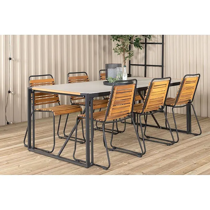 Ebuy24 Gartenstuhl Bois 4er-Set - 4 Stk., Stahl, Holz, Akazie Dekor, B x T x H: 57 x 59 x 86 cm - Essgruppe für draußen: Tisch mit grauer Platte, sechs Stühle mit Holzlatten und dunklem Metallgestell auf Holzterrasse.