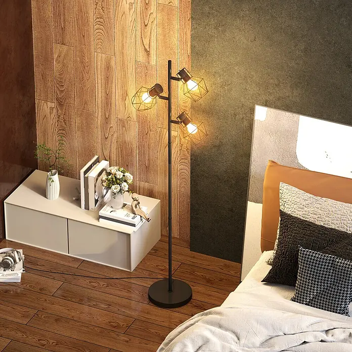 Homcom Stehleuchte - 40 W, Höhe: 169 cm, Schwarz, Schwarz, E27 - Eine schwarze Stehleuchte mit drei Metallkäfig-Schirmen steht in einem modernen Schlafzimmer und beleuchtet ein Bett und einen Nachttisch.