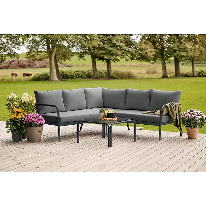 Ebuy24 Loungemöbel-Set Olga - 2 -tlg., Aluminium, Glas, Polyester, TPU, Schwarz - Dunkelgraues L-förmiges Outdoor-Sofa und Couchtisch auf Holzterrasse, bereit zur Entspannung.