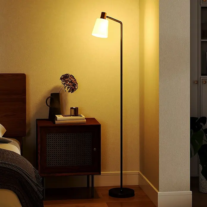 Homcom Stehleuchte - 25 W, Höhe: 148 cm, Schwarz, Weiß, E27 - Schwarze Stehlampe aus Metall mit weißem konischem Schirm und Holzdetails, die ein Schlafzimmer beleuchtet.
