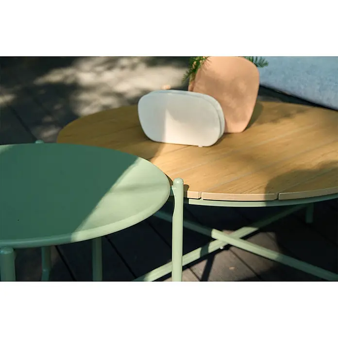 Ebuy24 Loungemöbel-Set Novella - 5 -tlg., Schaum, Polyester, Stahl, Grau - Runder Outdoor-Tisch-Set: ein hellgrüner und ein Holztisch mit Latten. Auf einer dunklen Holzterrasse platziert.