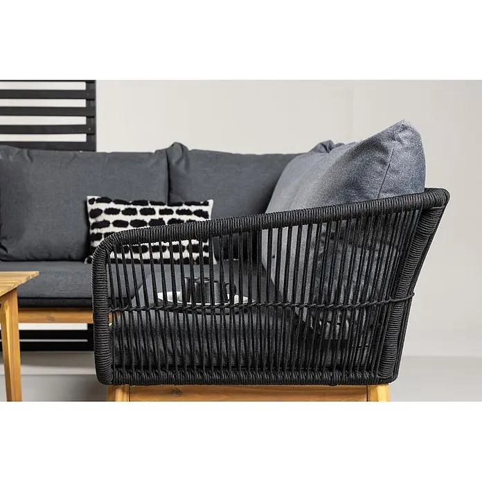 Ebuy24 Loungemöbel-Set Chania - 2 -tlg., Akazie, Schwarz - Outdoor-Ecksofa aus schwarzem Seilgeflecht mit dunkelgrauen Kissen und Holzfuß, in Lifestyle-Umgebung.