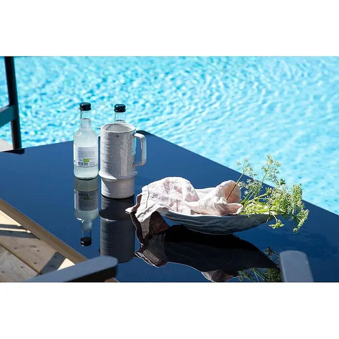 Ebuy24 Loungemöbel-Set Break - 4 -tlg., Aluminium, Schwarz - Heller Keramikkrug, Glasflaschen und eine graue Schale mit Leinentuch und Grünzeug auf einem dunklen Tisch am Pool.