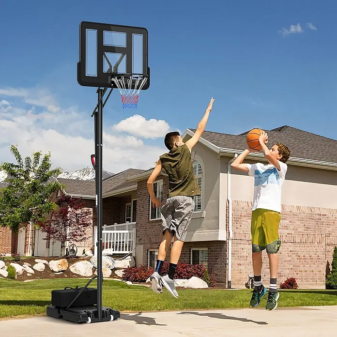 Sportnow Basketballkorb - Stahl, Schwarz - Schwarzer mobiler Basketballkorb mit transparenter Platte und rot-blauem Netz, von Jungen auf einer Einfahrt genutzt.