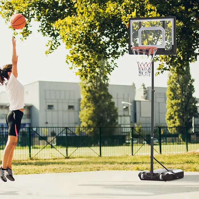Homcom Basketballkorb - Schwarz - Tragbarer schwarzer Basketballkorb mit klarer Rückwand und farbigem Netz, im Freien von einer Person beim Basketballspielen verwendet.