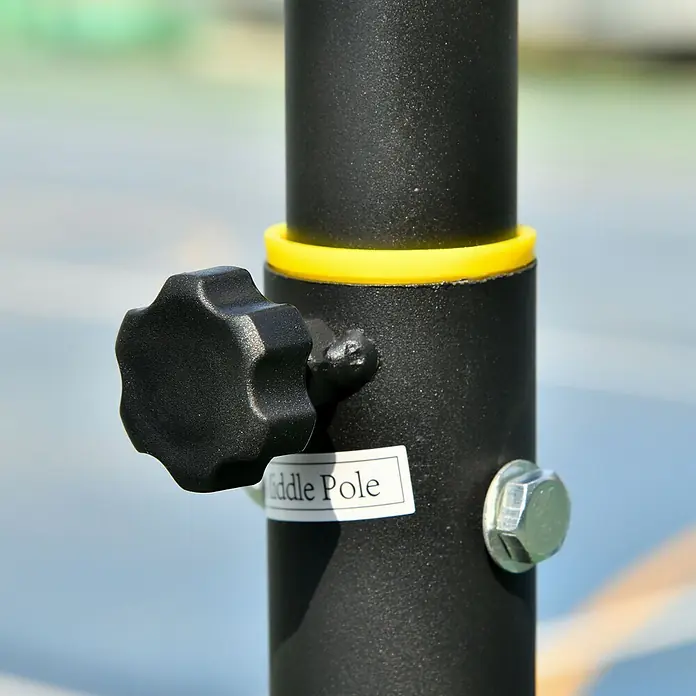 Homcom Basketballkorb - Schwarz - Nahaufnahme einer schwarzen, gesprenkelten Mittelstange mit gelbem Ring, schwarzem Stern-Drehknopf und silberner Schraube, vor verschwommenem Hintergrund.