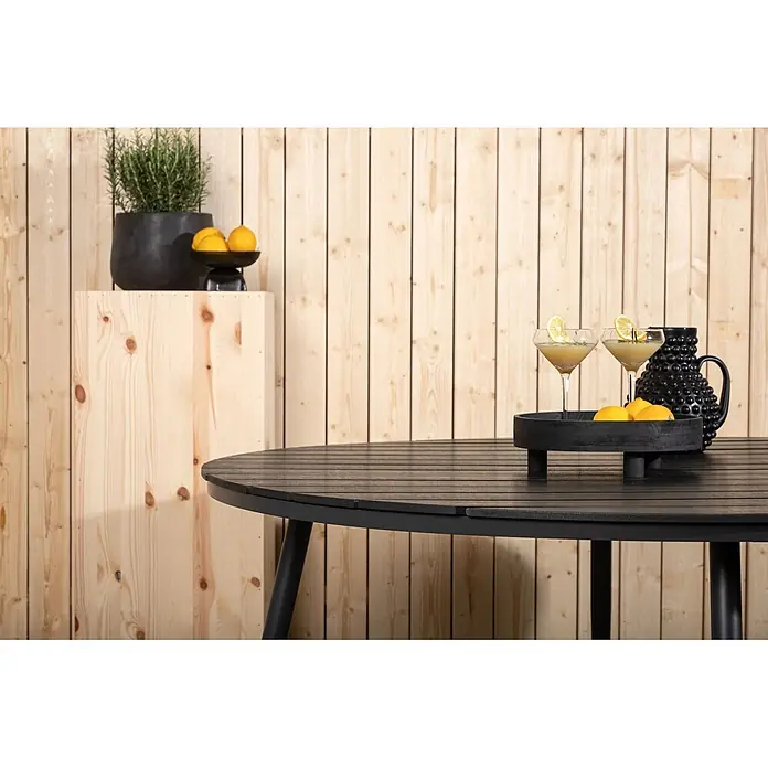 Ebuy24 Gartentisch rund Break - Ø x H: 150 x 74 cm, Aluminium, Schwarz, Stapelbar - Schwarzer runder Lamellen-Gartentisch, dekoriert mit Getränken und Zitronen.
