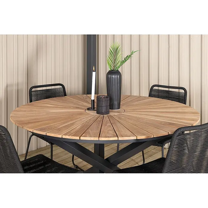Ebuy24 Gartentisch rund New Mexico - Ø x H: 140 x 75 cm, Aluminium, Teak, Schwarz, Stapelbar - Runder Outdoor-Esstisch mit Holzlamellenplatte, schwarzem Metallgestell und schwarzen Geflechtstühlen auf einer Terrasse.