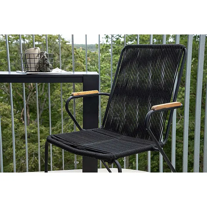Ebuy24 Gartensessel Bois - 1 Stk., Teak, Natur, B x T x H: 55 x 51 x 82 cm - Schwarzer Outdoor-Stuhl mit geflochtenem Seilsitz und Rückenlehne, Holzarmlehnen, auf einem Balkon neben einem Tisch.