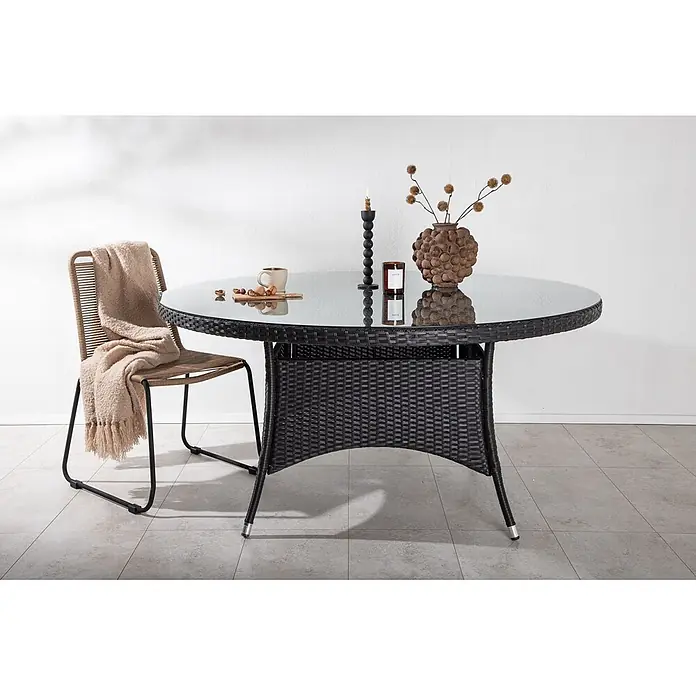 Ebuy24 Gartentisch rund Volta - Ø x H: 150 x 74 cm, Aluminium, Glas, Rattan, Schwarz, Stapelbar - Runder Outdoor-Esstisch mit Glasplatte und schwarzem Geflechtgestell, kombiniert mit passendem Stuhl mit hellbrauner geflochtener Rückenlehne.