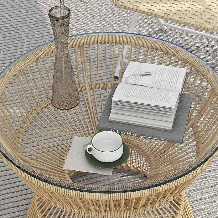 Outsunny Garten-Loungetisch im Boho-Design - Verzinkter Stahl, PE-Rattan, Hartglas, Naturholz - Runder heller Rattan-Couchtisch mit Glasplatte, auf einem gestreiften Teppich, dekoriert mit Büchern, einer Tasse und einer Vase.