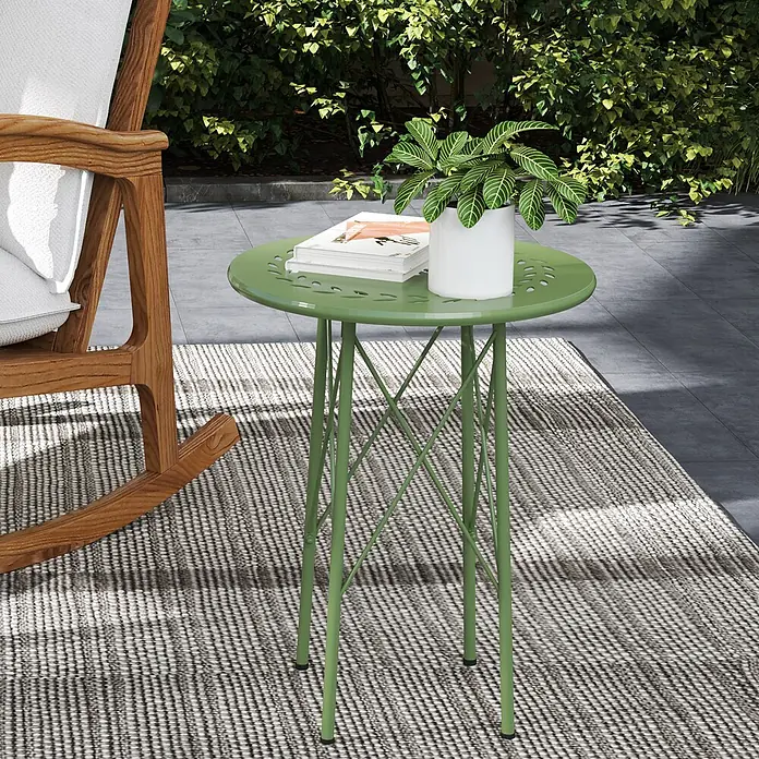 Outsunny Garten-Beistelltisch rund - Stahl, Grün - Grüner Metall-Beistelltisch für den Außenbereich, mit einer Pflanze und Büchern darauf, neben einem Schaukelstuhl.