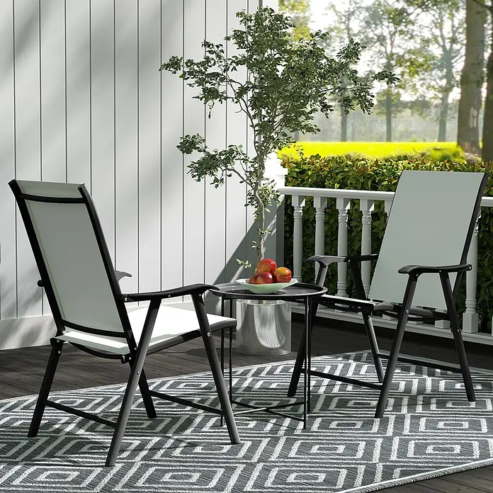 Outsunny Garten-Beistelltisch rund - Stahl, Schwarz - Zwei schwarzgerahmte Outdoor-Stühle mit hellem Stoff, kleiner schwarzer Beistelltisch mit Obst, und grauer geometrischer Teppich auf einer Terrasse.