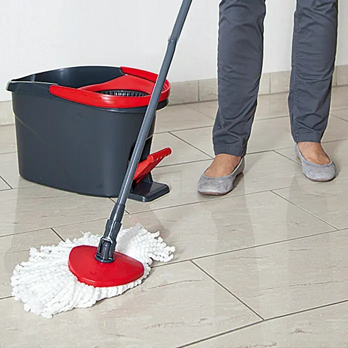 Vileda Easy Wring+Clean Wischmop-Set - Mikrofaser, 4 -tlg. - Eine Person wischt einen hellen Fliesenboden mit einem Wischmopp und Eimer. Das Reinigungsset ist rot und grau.