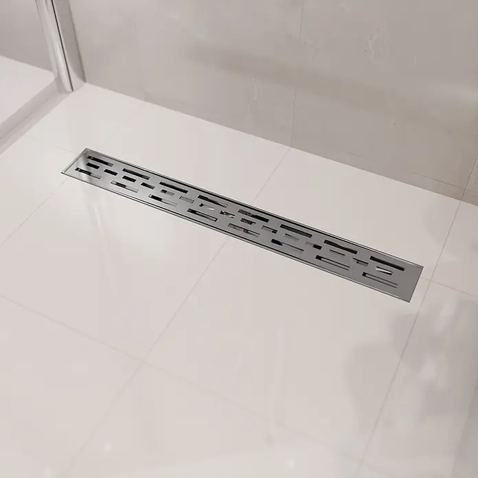 LOMAZOO Duschsystem SFD-01-BRUSHED-60 - Stahl - Silberne Linienentwässerung mit modern gemustertem Rost, in einer gefliesten Dusche installiert.