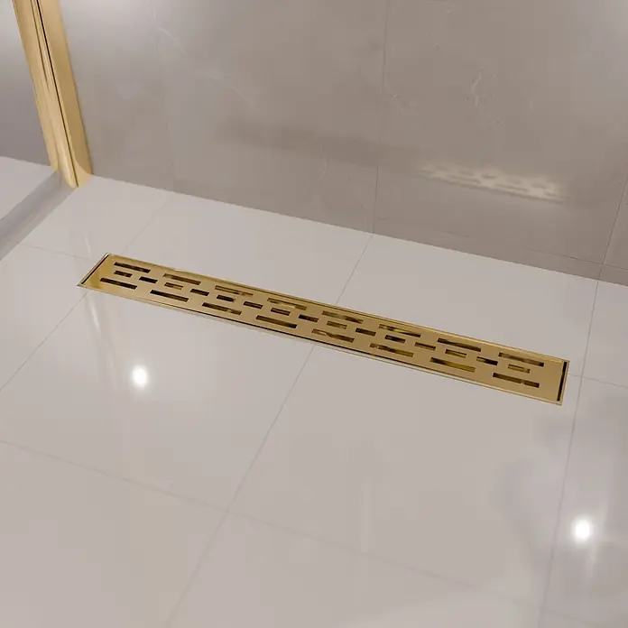 LOMAZOO Duschsystem SFD-01-GOLD-70 - Gold - Goldfarbener linearer Duschablauf mit geometrischem Musterrost, auf hellen Duschfliesen installiert.