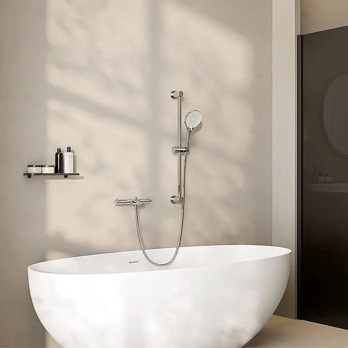 LOMAZOO Duschsystem LMZ-SELVO - Anzahl Strahlarten: 3 Stk., Glänzend - Moderne weiße freistehende Badewanne mit verchromter Duscharmatur an der Wand in einem minimalistischen Bad.