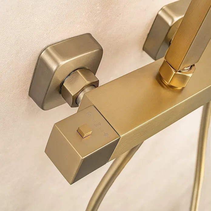 LOMAZOO Duschsystem LMZ-ESTRELLA - Anzahl Strahlarten: 1 Stk., Gold - Gebürsteter Messing-Duschmischer mit rechteckigem Design und Start/Stopp-Knopf, an heller Wand montiert.