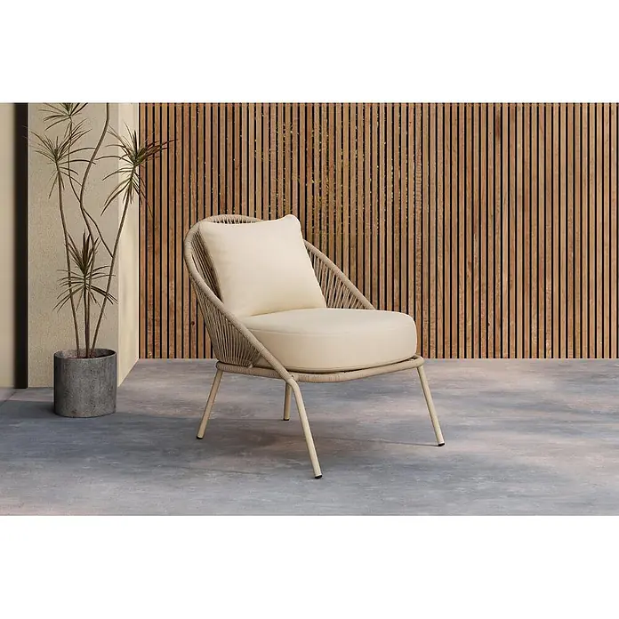 Ebuy24 Gartensessel Lindos 2er-Set - 2 Stk., Stahl, Beige, B x T x H: 74 x 81 x 77 cm - Ein moderner Outdoor-Lounge-Sessel mit hellbeigen Kissen, geflochtener Rückenlehne und hellem Metallgestell auf einer Betonterrasse.