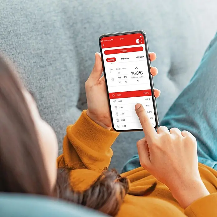 Hama Raumthermostat 00176629 Unterputz per App/Sprache steuern - Weiß - Eine Person nutzt eine Smartphone-App, um den Wochenplan der Smart-Home-Temperatur anzupassen.
