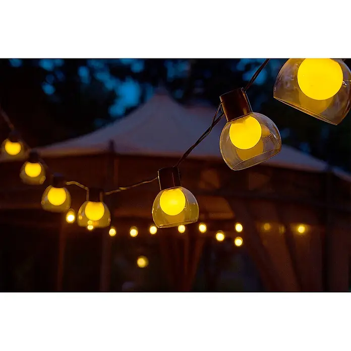 Garza Guirnalda luminosa solar Helios - Para exterior, Blanco cálido, 7 m, Número de bombillas: 10 ud., Con energía solar - Guirnalda de luces globo amarillas iluminadas sobre un fondo oscuro, creando un ambiente acogedor.