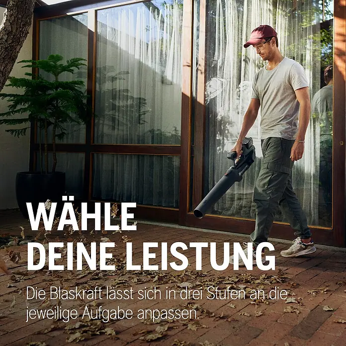 Husqvarna Akku-Laubbläser Aspire B8X-P4A - 1 Akku, Blasgeschwindigkeit: 144 km/h, Blasleistung: 10 m³/min - Mann in T-Shirt und Kappe nutzt einen schwarzen Husqvarna Laubbläser, um Blätter auf einer Terrasse zu räumen. Die Blaskraft ist einstellbar.