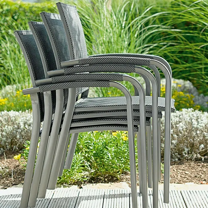 Sunfun Maja Sillón de jardín Maja - An x Pr x Al: 59,5 x 59 x 88 cm, Antracita, Aluminio/Textiline - Pila de cuatro sillas de jardín grises y negras de metal y textil en un patio al aire libre.