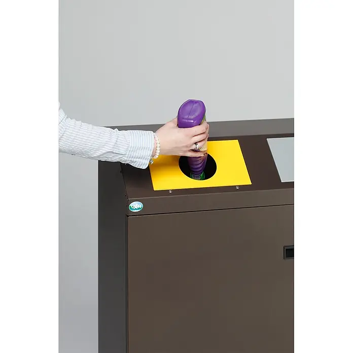 Proregal Wertstoffsammler selbstlöschend mit 3 Einsätzen - 80 l - Brauner Recyclingbehälter mit gelber Öffnung, eine Hand entsorgt eine lila Plastikflasche.