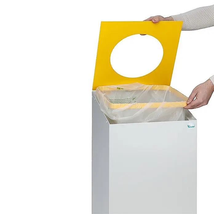 Proregal Wertstoffsammler robust & modular mit runder Einwurföffnung - 100 l - Weißer Recyclingbehälter mit gelbem Deckel, runder Öffnung und transparentem Beutel. Hände richten den Beutel ein.