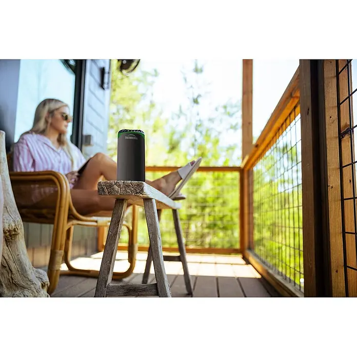 Thermacell Stechmückenschutz Tischgerät Protect mit Gaskartusche & Citrodiol® Wirkstoffblättchen - Schwarz/Grün, Wirkungsbereich: 15 m² - Schwarzes zylindrisches Thermacell Mückenschutzgerät mit grünem Deckel auf Holzschemel auf Veranda für Komfort im Freien.