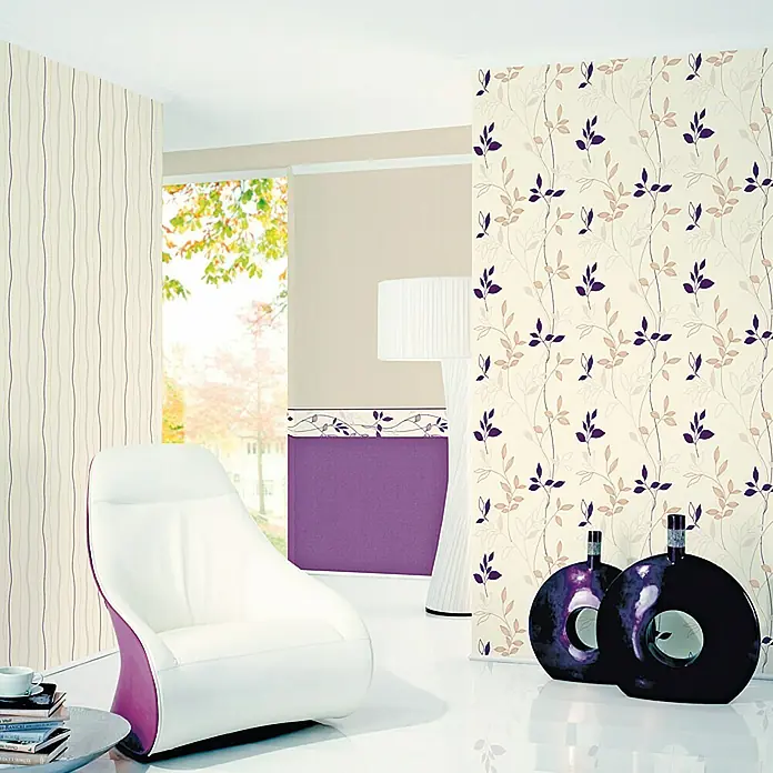 A.S. Création Casual Living Vliestapete - Creme-Weiß, Uni, 10,05 x 0,53 m - Ein modernes Interieur mit floraler Tapete, einem Sessel und dekorativen Vasen, die eine stilvolle Raumatmosphäre schaffen.